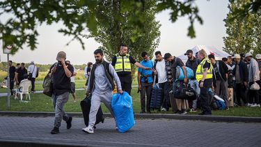 TER APEL - Asielzoekers worden bij het aanmeldcentrum, waar de opvanglocatie overvol is, opgehaald om de nacht door te brengen in Groningen. Het Rode Kruis plaatste overdag extra tenten op het grasveld als beschutting tegen de zon. De tenten waren niet bedoeld om onder te slapen. JASPAR MOULIJN / ANP