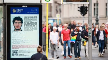 epa13134271 People attending a mourning march following a car-ramming attack near the Christopher Street Day (CSD) parade route pass an electronic display showing a police appeal for information about suspected perpetrator Abdul B. in Berlin, Germany, 26 July 2026. Police said the suspect was believed to be linked to Islamist circles, while German Interior Minister Alexander Dobrindt said the 25 July vehicle ramming, which killed one person and injured 29 others, is being investigated as a terrorist attack.  EPA/CLEMENS BILAN