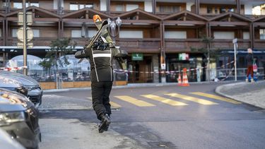 epa12620173 A skier walks in a street near the site where a fire broke out at the Le Constellation bar and lounge following an explosion in the early hours of New Year's Eve, in Crans-Montana, Switzerland, 01 January 2026. According to regional media, the incident caused several deaths and injuries, while the exact cause of the blaze was not immediately known, Swiss cantonal police said.  EPA/ALESSANDRO DELLA VALLE