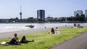 Een foto van mensen die aan de waterkant genieten van een warme dag in Rotterdam