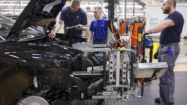 epa12774800 Volkswagen employees is seen working on a car at the Volkswagen factory in Emden, Germany, 24 February 2026. The Volkswagen (VW) factory in Emden builds fully electric Volkswagen vehicles such as the ID.4 and ID.7 models as part of the company’s shift to electric mobility.  EPA/CHRISTOPHER NEUNDORF