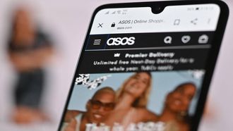 An illustration with a laptop and mobile phone shows the website of online fashion retailer ASOS on August 12, 2021. 
JUSTIN TALLIS / AFP
