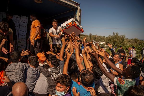 Migranten uit Moria tijdens het uitdelen van eten nadat het kamp werd verwoest