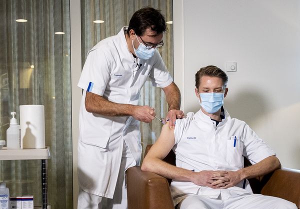 Een foto van Diederik Gommers die het vaccin toedient aan verpleegkundige Tom