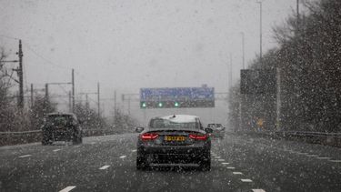 AMSTERDAM - Auto’s op de snelweg tijdens een winterse bui. Buien met hagel en (natte) sneeuw trekken over Nederland. ROBIN VAN LONKHUIJSEN / ANP