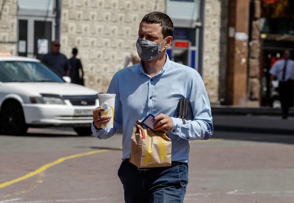 Een foto van man met eten en een milkshake van McDonald's in zijn handen