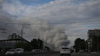 Cars drive along down street as smoke rises in the background, following Russian strikes in the city of Dnipro on June 3, 2026, amid the Russian invasion of Ukraine. 
Genya SAVILOV / AFP