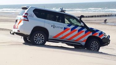 Op deze foto is een politieauto te zien op het strand waar de cocaïne was aangespoeld.
