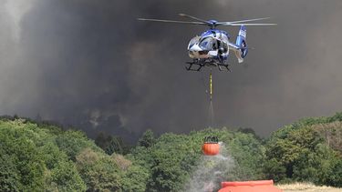 A police helicopter loads water to fight a forest fire in Huertgenwald, western Germany on August 14, 2026. Around 1,800 people had to leave their homes in western Germany overnight as a wildfire spread nearby, officials said, with helicopters and army equipment deployed to help battle the flames. A district of the town of Huertgenwald near the Belgian and Dutch borders was evacuated after the fire expanded from 25 hectares (around 60 acres) to 300 hectares by Friday morning.
Roberto Pfeil / afp