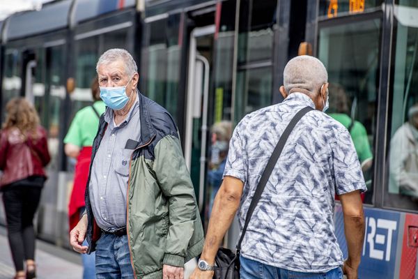 Op deze foto zie je een man in Rotterdam uit de metro stappen die een mondkapje draagt
