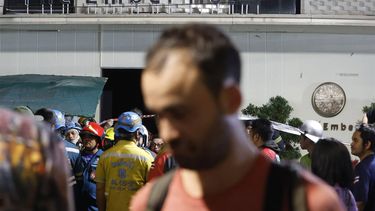 epa11797948 A tourist walks past the scene after a blaze at The Ember Hotel in Bangkok, Thailand, 29 December 2024. According to police at the scene, a number of casualties were reported when a fire broke out at the hotel near the tourist spot of Khao San Road.