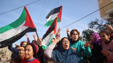Displaced Palestinians waving national flags cheer as they return to Rafah in the southern Gaza Strip on January 19, 2025, hours after a ceasefire deal in the war between Israel and the Palestinian militant group Hamas was expected to be implemented.  
Eyad BABA / AFP