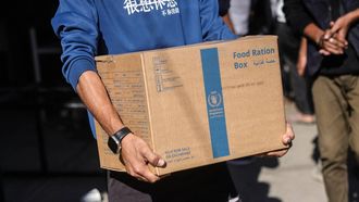 A Palestinian man carries a food ration box provided by the World Food Programme (WFP), at a distribution centre in the village of Al-Zawayda, in the centre of the Gaza Strip on October 27, 2025. Aid agencies complain that humanitarian convoys still do not have enough access to Gaza to alleviate the famine conditions in parts of the territory, and families there are still going hungry, on October 26, 2025. 
BASHAR TALEB / AFP