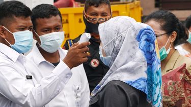 Een foto van het dragen van een mondkapje wat in Indonesië in maart al heel normaal was