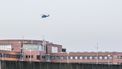 Op deze foto is een helikopter te zien die boven de gevangenis in Zutphen vliegt.