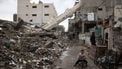 A Palestinian child rides a bicycle near a fallen minaret of a destroyed mosque during the Muslim holy fasting month of Ramadan, in the Nuseirat refugee camp in the central Gaza Strip on March 7, 2025.   
Eyad BABA / AFP