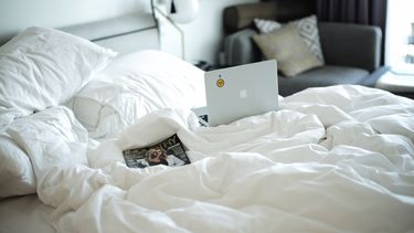 Een laptop op een bed.