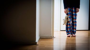 ILLUSTRATIE DEN HAAG - Een jongen in pyjama met knuffelbeer staat in de deuropening. ANP  ROOS KOOLE