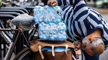 HORST AAN DE MAAS - Mensen verlaten een supermarkt met flessen drinkwater. Drinkwaterbedrijf Waterleiding Maatschappij Limburg (WML) heeft tijdens een controle een lichte verontreiniging met de poepbacterie E. coli aangetroffen in het drinkwater en adviseert inwoners kraanwater eerst drie minuten te koken. ANP ROB ENGELAAR