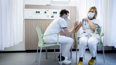 Een foto van het toedienen van het coronavaccin in een ziekenhuis in Den Haag