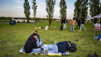 TER APEL - Asielzoekers bij het aanmeldcentrum, waar de opvanglocatie overvol is. Het Rode Kruis plaatse overdag vier tenten op het grasveld als beschutting tegen de zon. De tenten waren niet bedoeld om onder te slapen. MARCEL J. DE JONG / ANP