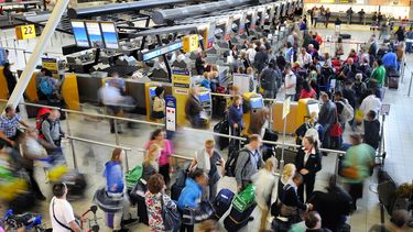 Reizigers op de luchthaven. Foto: ANP Reisexpert tipt 'jokerdagen' om vakantiedrukte te verminderen