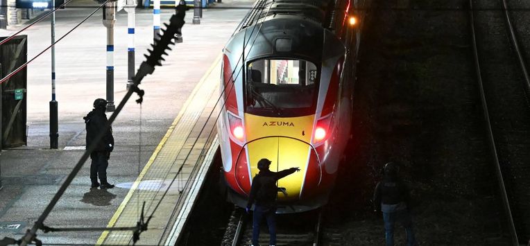 Police officers and search the track in front of an LNER Azuma train at Huntingdon Station in Huntingdon, eastern England, on November 1, 2025, following a stabbing on a train.  UK police said they had arrested two suspects Saturday as 