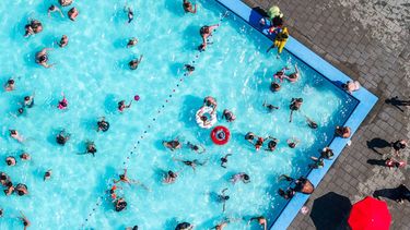 MIJNSHEERENLAND - Dronefoto van zonaanbidders en badgasten die verkoeling zoeken in een buitenbad op een zonovergoten dag. De temperatuur stijgt tot boven de dertig graden. JEFFERY GROENEWEG / ANP