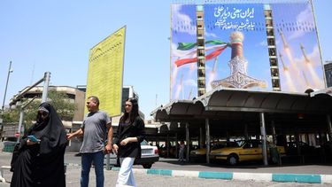 epa13029912 Iranians walk past a large-scale political billboard featuring Iranian missiles and a sword at Vanak square in Tehran, Iran, 11 June 2026. A ceasefire framework established between Washington and Tehran in April faces increasing strain following a series of US airstrikes across Iran and subsequent retaliatory missile barrages by the Islamic Revolutionary Guard Corps (IRGC) targeting US regional bases.  EPA/ABEDIN TAHERKENAREH RESTRICTIONS: NO Access Israel Media/Persian Language TV Stations Outside Iran/Strictly No Access BBC Persian/VOA Persian/Manoto TV/Iran International TV. (As mandated by Iran's Directorate General for Foreign Media) --