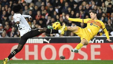 Valencia's Portuguese defender #12 Thierry Correia vies with Barcelona's Polish forward #09 Robert Lewandowski during the Spanish league football match between Valencia CF and FC Barcelona at the Mestalla stadium in Valencia on December 16, 2023. 
JOSE JORDAN / AFP