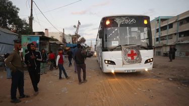 Palestinian youths watch as a bus bearing the emblem of the International Red Cross moves towards the eastern Gaza Strip from Khan Yunis in the south of the besieged territory on October 13, 2025, ahead of the release of Israeli hostages held by Hamas since the October 7 attacks two years ago. On the other side, a Red Cross convoy is on its way to pick up a first batch of Israeli hostages to be freed by Hamas as part of a Gaza ceasefire deal announced by US President Donald Trump earlier this month, the Israeli military said on October 13.

Omar AL-QATTAA / AFP