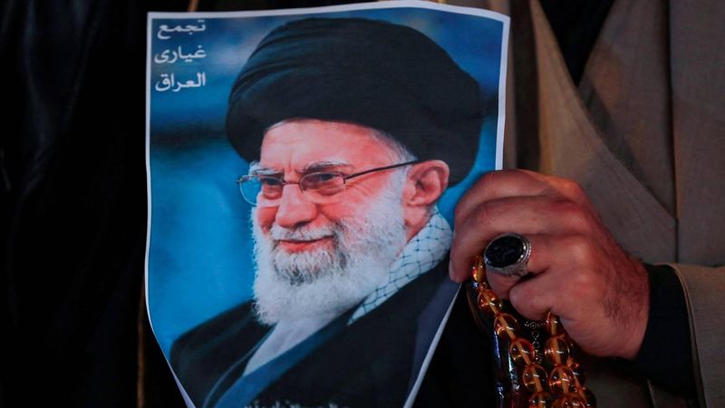 A Shiite Muslim man hold a poster of the late Iranian supreme leader Ayatollah Ali Khamenei, assassinated in a US- Israeli attack on Tehran, and a set of prayer beads during a rally in Tahrir Square, in the Baghdad on March 6, 2026.  The United States and Israel launched strikes against Iran on February 28, killing Iran's supreme leader and top military leaders, prompting authorities to retaliate with strikes on Israel and across the Gulf. Fresh strikes rocked Iran and Lebanon on March 6, as Israel and the United States stepped up their attacks in the sprawling Middle East war, with powerful explosions shattering the skies of Tehran.
Murtaja LATEEF / AFP