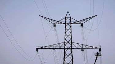 HANSWEERT - Medewerkers van TenneT verwijderen de lijnen uit een hoogspanningsmast. In Zeeland wordt een aantal masten verwijderd om plaats te maken voor nieuwe. Om de hoogspanningslijnen te kunnen weghalen, moet het scheepvaartverkeer op het Kanaal van Zuid-Beveland meermaals worden stilgelegd. ROBIN VAN LONKHUIJSEN / ANP
