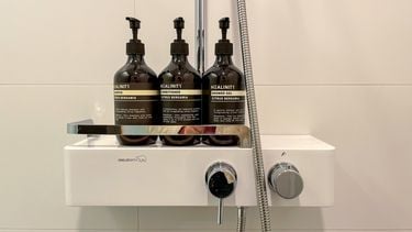 Drie flessen shampoo, conditioner en douchegel in een hotel.