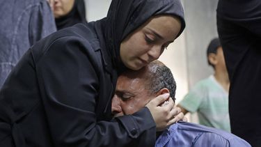 Mourners weep next to the body of one of the Palestinian who died after an Israeli airstrike targeted a residential apartment in the Sabra neighborhood of Gaza City on July 21, 2026. Israeli forces currently control more than 60 percent of the Gaza Strip, where daily violence continues despite a ceasefire between Israel and Palestinian group Hamas.
Omar AL-QATTAA / AFP