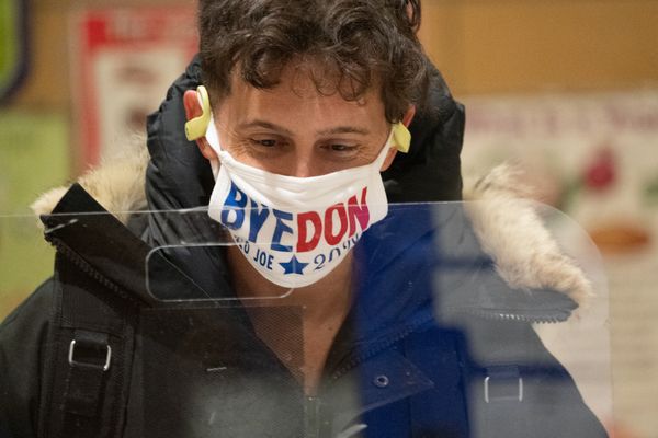 Een foto van een Amerikaan die stemt met een mondkapje met de tekst Bye Don