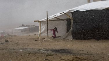 2023-11-19 14:25:19 epa10985191 A youngster takes shelter from the rain at a temporary camp provided by the United Nations Development Program for displaced Palestinians who lost their homes in Israeli raids, in Khan Yunis, 19 November 2023. More than 12,000 Palestinians and at least 1,200 Israelis have been killed, according to the Israel Defense Forces (IDF) and the Palestinian health authority, since Hamas militants launched an attack against Israel from the Gaza Strip on 07 October, and the Israeli operations in Gaza and the West Bank which followed it.  EPA/HAITHAM IMAD