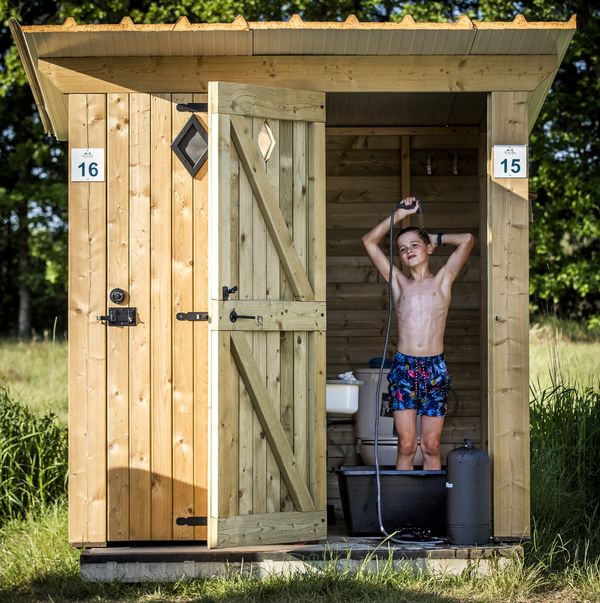 Een foto van een jonge campinggast in een privé-sanitair in Garderen.