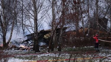 A Lithuanian medic takes a photo on his mobile phone of the wreckage of a cargo plane following its crash near the Vilnius International Airport in Vilnius on November 25, 2024. 
Petras Malukas / AFP
