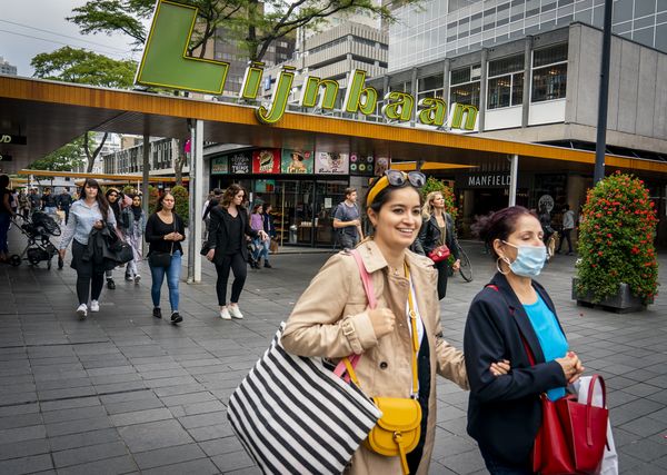 Een foto van twee meisjes in Rotterdam, één zonder mondkapje, één met