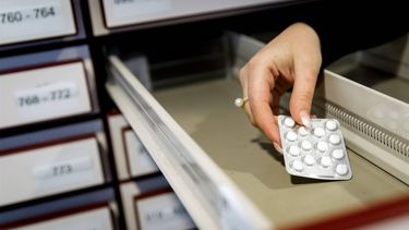 DEN HAAG - Een apothekersassistente zoekt medicijnen bij elkaar in een apotheek. ANP KOEN VAN WEEL