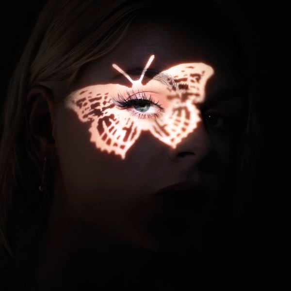 Een foto van de cover van my own world van Davina Michelle. Haar gezicht is verlicht met een vlinder