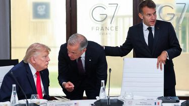 US President Donald Trump speaks with Canada's Prime Minister Mark Carney next to France's President Emmanuel Macron during a work lunch as part of the G7 summit, in Evian, eastern France, on June 16, 2026. A G7 summit is set to take place June 15 to 17 in the French town of Evian-les-Bains near Switzerland and it will be attended by country leaders as well as the EU's foreign policy chief and ministers from Brazil, Canada, the United Arab Emirates and Turkey.
Christian Hartmann / POOL / AFP