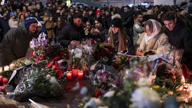epa12621050 Several hundred mourners gather to lay down flowers and light candles to remember the victims of the fire at the 