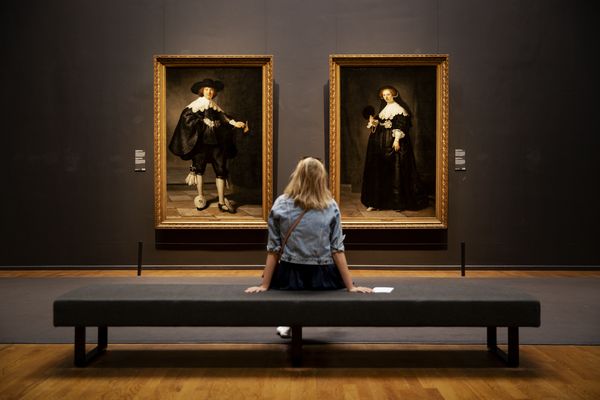 Een foto van een bezoekster van het Rijksmuseum waar je nu een mondkapje moet dragen