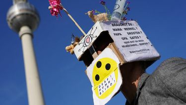 Een foto van een man met een gek masker die in Berlijn protesteert tegen de coronamaatregelen