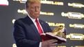 Republican presidential candidate former President Donald Trump holds gold Trump sneakers at Sneaker Con Philadelphia, an event popular among sneaker collectors, in Philadelphia, Saturday, Feb. 17, 2024. (AP Photo/Manuel Balce Ceneta)